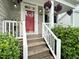 Inviting front porch with a bright red door, hanging plants, and meticulously maintained landscaping at 8640 Swarthmore Dr, Raleigh, NC 27615