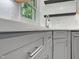 Close-up of a kitchen corner featuring stainless steel appliances, gray cabinetry, and white quartz countertops at 8640 Swarthmore Dr, Raleigh, NC 27615