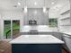 Bright, open kitchen featuring gray cabinetry, a blue island with quartz countertops and stainless steel appliances at 8640 Swarthmore Dr, Raleigh, NC 27615