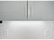 Detailed view of kitchen cabinets, subway tile backsplash, and electrical outlets under modern cabinets at 8640 Swarthmore Dr, Raleigh, NC 27615