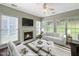 Bright, virtually staged living room featuring a fireplace, large windows, and a comfortable seating arrangement at 8640 Swarthmore Dr, Raleigh, NC 27615