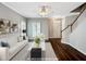 Inviting, virtually staged living room with hardwood floors, a staircase, and stylish modern furnishings at 8640 Swarthmore Dr, Raleigh, NC 27615