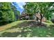 View of the home's exterior showcasing a sloped backyard with a deck and well-maintained lawn at 8715 Macedonia Lake Dr, Cary, NC 27518