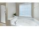 Bathroom featuring a white soaking tub, shower with glass doors, and a bright window at 8715 Macedonia Lake Dr, Cary, NC 27518