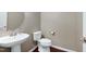 Powder room featuring a pedestal sink, toilet, and round mirror against a neutral wall at 8715 Macedonia Lake Dr, Cary, NC 27518