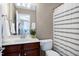 Cozy bathroom featuring a single sink vanity, toilet, and tub with a patterned shower curtain at 8715 Macedonia Lake Dr, Cary, NC 27518