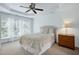 Bedroom features a tray ceiling with fan, natural light from three windows, and neutral decor at 8715 Macedonia Lake Dr, Cary, NC 27518