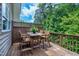 Outdoor wooden deck featuring a dining table, four chairs, and a wooden privacy panel and railing at 8715 Macedonia Lake Dr, Cary, NC 27518