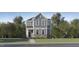 Charming two-story home with stone accents, gray siding, a well-manicured lawn, and mature trees at 876 Cassa Clubhouse Way, Knightdale, NC 27545