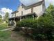 Two-story home featuring an accessible ramp and a screened-in porch, set amid mature foliage at 94 Bynum Church Rd, Pittsboro, NC 27312