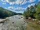Picturesque river view featuring rocks, flowing water, and green trees at 94 Bynum Church Rd, Pittsboro, NC 27312