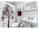A well-lit bathroom with storage cabinet, pedestal sink, and tree shower curtain at 99 Winwood Dr, Angier, NC 27501