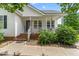 Charming single-story home with a welcoming front porch, brick steps, and manicured landscaping at 99 Winwood Dr, Angier, NC 27501