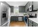 A charming kitchen featuring gray cabinets, stainless steel appliances, and hardwood floors at 99 Winwood Dr, Angier, NC 27501