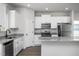 Modern kitchen with white cabinets, granite countertops, stainless steel appliances, and laminate flooring at 1004 Rhino Bnd, Oxford, NC 27565