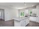 Kitchen island features a granite countertop, white cabinets, and laminate flooring at 1004 Rhino Bnd, Oxford, NC 27565
