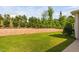 Spacious backyard featuring retaining wall, manicured lawn, and lush green trees at 1019 Santiago St, Durham, NC 27703