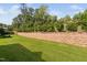 Backyard featuring retaining wall, manicured lawn, and lush green trees at 1019 Santiago St, Durham, NC 27703