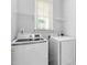 Convenient laundry room features shelving, a window, and a modern washer and dryer at 1019 Santiago St, Durham, NC 27703