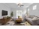 A living room with a gray sofa, carpeting, neutral walls, and a door leading to an office space at 1019 Santiago St, Durham, NC 27703