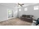 Living room featuring a ceiling fan, carpet, and a glass-paneled door at 1019 Santiago St, Durham, NC 27703