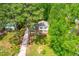 Aerial view of home with a red door, a driveway, mature trees, green lawns, and surrounded by lush greenery at 102 Emerald Cir, Durham, NC 27713