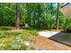 Backyard with a concrete patio, storage shed, stone walkway, lawn and mulch, and surrounded by lush trees at 102 Emerald Cir, Durham, NC 27713
