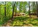 Back of house with siding and brick, a concrete patio, and surrounded by a lush green lawn and mature trees at 102 Emerald Cir, Durham, NC 27713