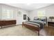 Well-lit bedroom with modern decor, neutral colors, wood furniture, and windows for natural light at 102 Emerald Cir, Durham, NC 27713