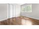 Inviting bedroom featuring hardwood floors, closet space, and a window offering natural light at 102 Emerald Cir, Durham, NC 27713