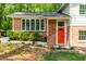 Close up of this home's stylish front entrance with brick facade and a vibrant red door at 102 Emerald Cir, Durham, NC 27713