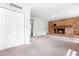 Spacious carpeted living room featuring a brick fireplace, perfect for gatherings and relaxation at 102 Emerald Cir, Durham, NC 27713