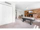 Carpeted living room with a brick fireplace and entertainment center featuring an air hockey table at 102 Emerald Cir, Durham, NC 27713