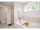 Bright bathroom features a soaking tub, separate shower, and natural light from the window at 103 Foothill Ct, Sanford, NC 27330