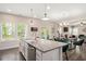 Kitchen island featuring granite countertops, stainless steel dishwasher, and seating with views to the dining area at 103 Foothill Ct, Sanford, NC 27330