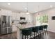 Modern kitchen with white cabinets, granite countertops, stainless steel appliances, and bar stool seating at 103 Foothill Ct, Sanford, NC 27330