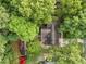 An aerial view shows a charming home nestled among lush green trees, with red cars parked nearby at 1040 Ivy Ln, Cary, NC 27511