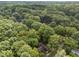 An aerial view shows a home with a brown roof nestled among the green trees in this sought after neighborhood at 1040 Ivy Ln, Cary, NC 27511