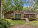 Lush backyard with a mix of grass and foliage, featuring a patio and a wooded area at 1040 Ivy Ln, Cary, NC 27511