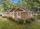 This brick house has well-maintained landscaping, an American flag, neutral siding and white trimmed windows at 1040 Ivy Ln, Cary, NC 27511
