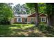 A well-maintained brick house surrounded by mature trees offers a serene and private setting at 1040 Ivy Ln, Cary, NC 27511
