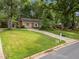 Charming home with lush green lawn, mature trees, and a long drive, providing ample parking at 1040 Ivy Ln, Cary, NC 27511