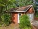 Garage exterior surrounded by verdant landscaping and a stone pathway leading to the door at 1040 Ivy Ln, Cary, NC 27511