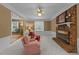 Second living room boasting brick fireplace, ceiling fan, and plush carpet at 1040 Ivy Ln, Cary, NC 27511