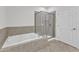 Bathroom with soaking tub, glass enclosed shower, and neutral tile flooring at 10511 Sablewood Dr # 107, Raleigh, NC 27617