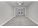 Bright bedroom featuring architectural columns, neutral walls, and soft carpeting at 10511 Sablewood Dr # 107, Raleigh, NC 27617