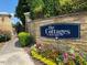 Stone wall featuring the Cottages at Brier Creek community sign surrounded by colorful flowers and landscaping at 10511 Sablewood Dr # 107, Raleigh, NC 27617