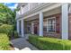 Charming entryway of brick townhouse with covered front porch, bright windows, and manicured bushes at 10511 Sablewood Dr # 107, Raleigh, NC 27617