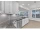 Bright kitchen featuring granite countertops, stainless steel dishwasher, and white cabinetry at 10511 Sablewood Dr # 107, Raleigh, NC 27617