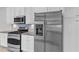 Stainless steel refrigerator in a modern kitchen with stainless appliances and white cabinetry at 10511 Sablewood Dr # 107, Raleigh, NC 27617